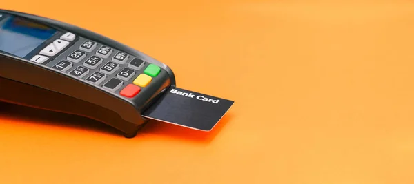 Payment Pos terminal with bank card and copy space. Contactless and cashless acceptance of payments by bank card or phone. Business and technology.