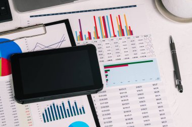 Tabletli, belgeli ve grafikli bir işyeri. Geliri ve masrafları planlamak. Vergi hesaplama ve bütçe planlaması