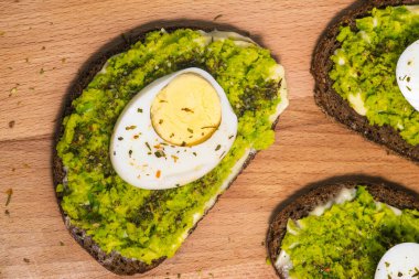 Avokado kapaklı sandviçler. Yumurtalı tost ve avokado püresi. Kahvaltı, öğle yemeği ya da akşam yemeği. Sağlıklı yemek, vejetaryen atıştırması.