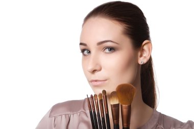 Farklı makyaj fırçaları tutan güzel genç kadın. Beyaz bir arka plan üzerinde izole