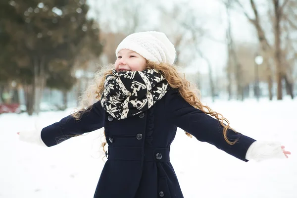 Baby girl having fun in the winter snow-covered park — Stock Photo, Image