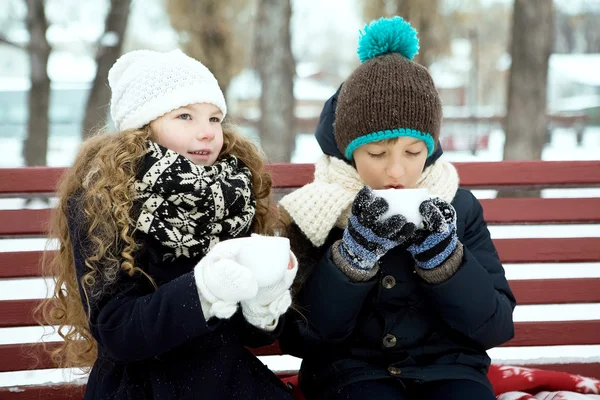 Boy with girl drink coffee together in the winter on a bench in — Stock Photo, Image