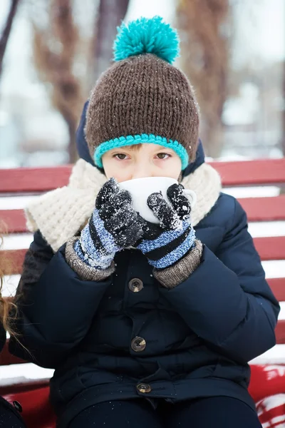 Little boy heated hot coffee frosty winter in snow-covered park — Stock Photo, Image
