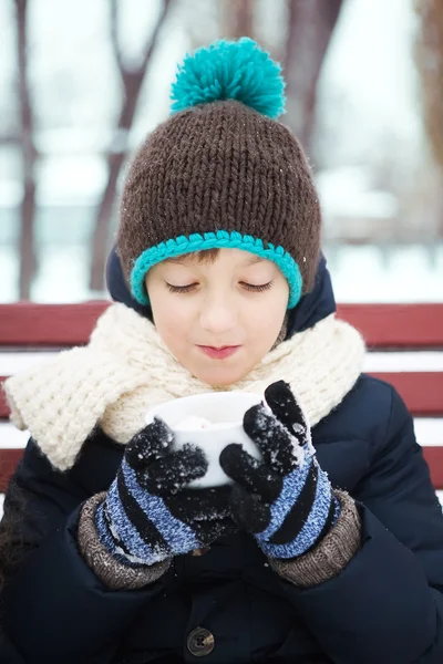 Little boy heated hot coffee frosty winter in snow-covered park — Stock Photo, Image