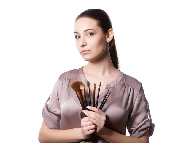 Vacker ung kvinna med olika make-up penslar. Isolerad på en vit bakgrund — Stockfoto