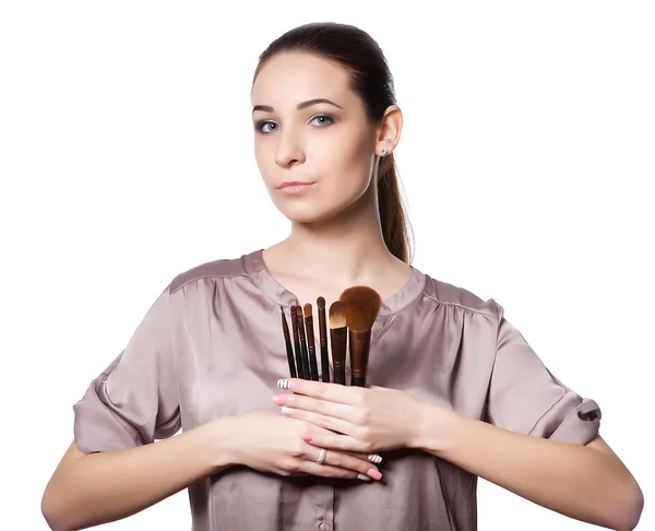 Vacker ung kvinna med olika make-up penslar. Isolerad på en vit bakgrund — Stockfoto