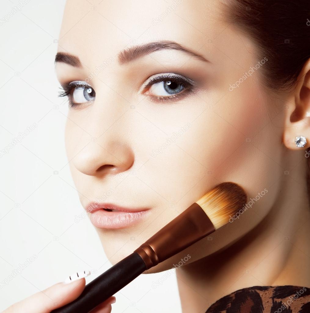 Beauty young Girl with Makeup Brushes. Natural Makeup for