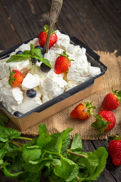 cottage cheese in black cardboard packaging with berries, blueberries, strawberries and mint leaf, top and side shot, burlap, on black isolated background