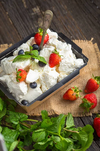 cottage cheese in black cardboard packaging with berries, blueberries, strawberries and mint leaf, top and side shot, burlap, on black isolated background