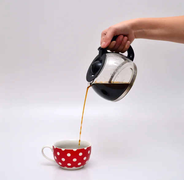 Mulher mão derramando café em uma caneca Fotografia De Stock