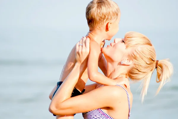 Niño feliz con mamá joven en el mar —  Fotos de Stock