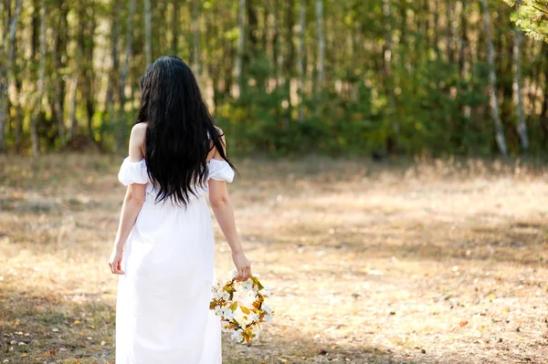 Vrouw in het bos met bloemen — Stockfoto