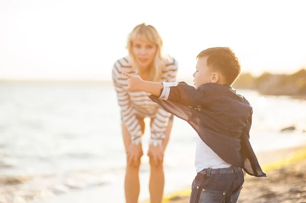 Vacker kvinna med ett barn på stranden. — Stockfoto