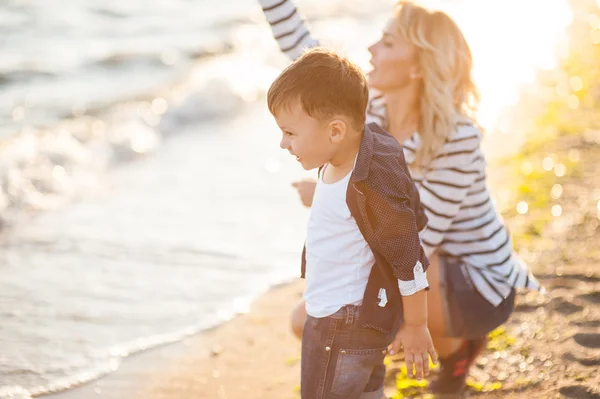 Vacker kvinna med ett barn på stranden. — Stockfoto