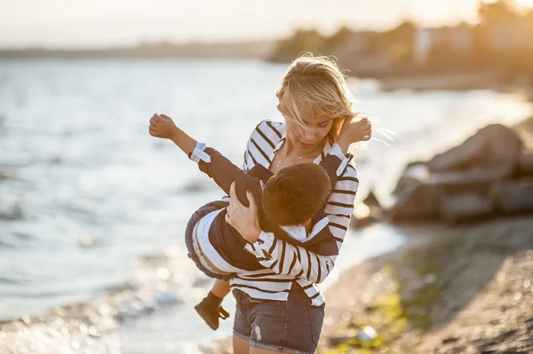 Hermosa mujer con un niño en la playa . —  Fotos de Stock