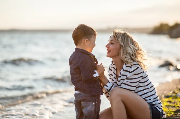 美丽的女子和一个孩子在沙滩上. — 图库照片