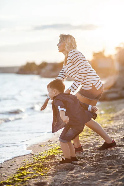 Vacker kvinna med ett barn på stranden. — Stockfoto