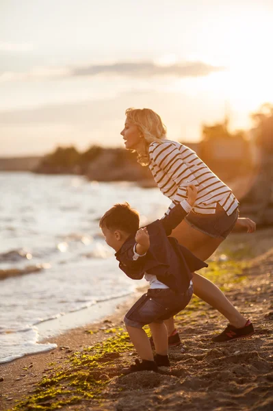 Vacker kvinna med ett barn på stranden. — Stockfoto