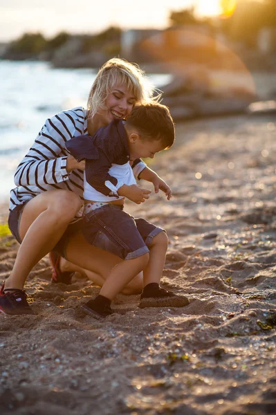 Hermosa mujer con un niño en la playa . —  Fotos de Stock