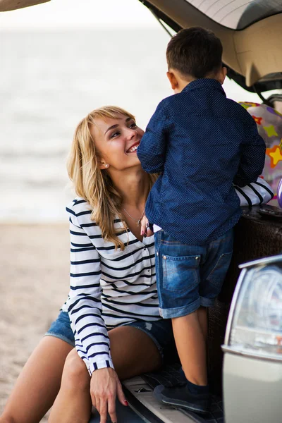 Belle femme avec un enfant près de la machine . — Photo