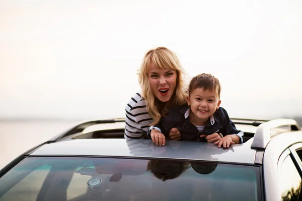 Belle femme avec un enfant dans la voiture . — Photo