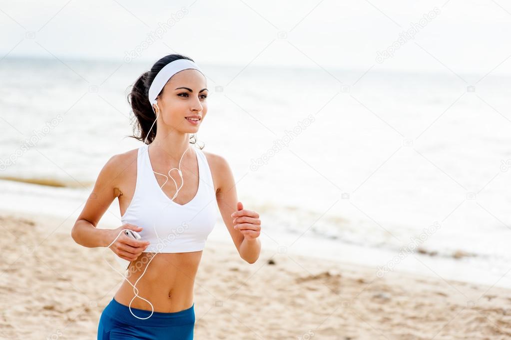 Young woman on beach doing exercises