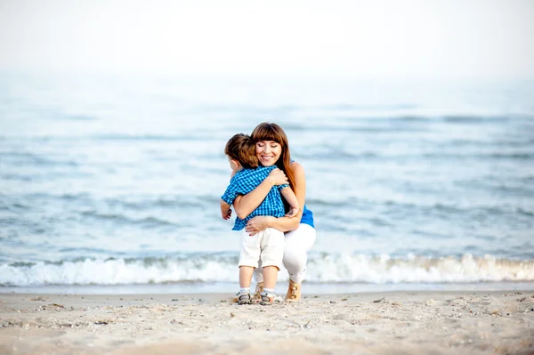 Mãe e filho pequeno têm um resto na praia . — Fotografia de Stock