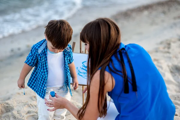 Mor och son har en vila på stranden. — Stockfoto