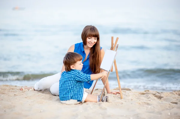 Mãe e filho têm um descanso na praia . — Fotografia de Stock