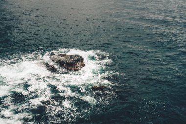 Dalgalar kıyıya yakın kayaları siler..