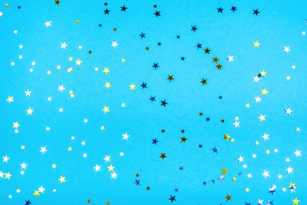 Étoiles dorées et argentées sur fond bleu. — Photo