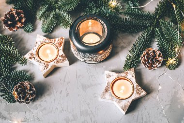 Noel arkaplanda şamdanların, köknar dallarının ve çelenklerin Noel kompozisyonu.