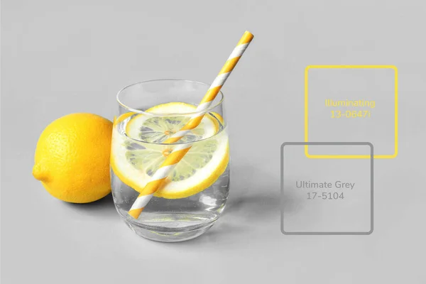 Un bicchiere di limonata con limone su fondo grigio. Fotografia Stock