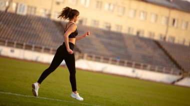 Fitness kızı dışarıda bacak egzersizi yapıyor.