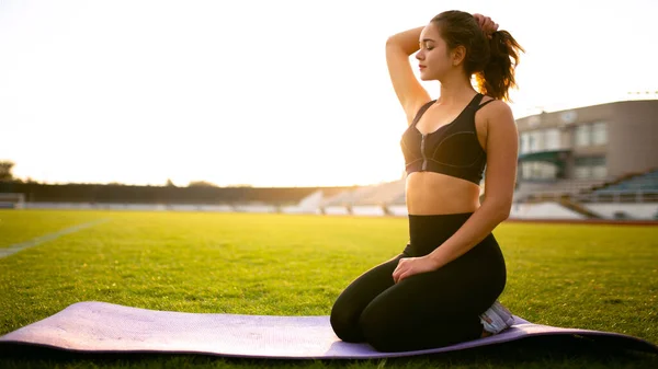 Chica de fitness haciendo ejercicio en la pierna en el estadio al aire libre — Foto de Stock