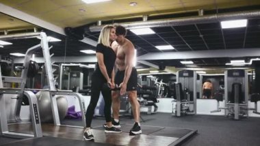 Kol egzersizleri yapan genç ve güzel bir kız. Kişisel fitness eğitmeniyle.