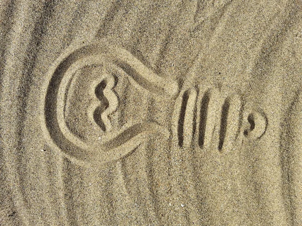 Bola lampu listrik, menggambar di pasir — Stok Foto