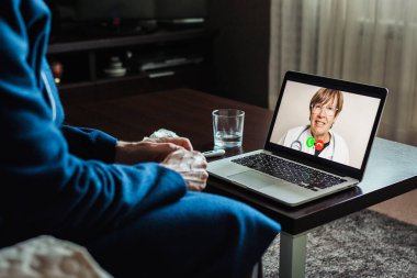 Hasta adam bilgisayardaki doktorla çevrimiçi istişare yapıyor.