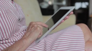Dijital tablet kullanan emekli yaşlı kadın