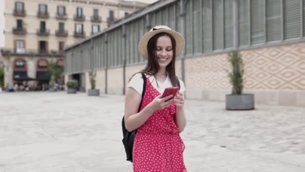 Gelukkige jonge toeristische vrouw die mobiele telefoon gebruikt tijdens een bezoek aan Barcelona — Stockvideo