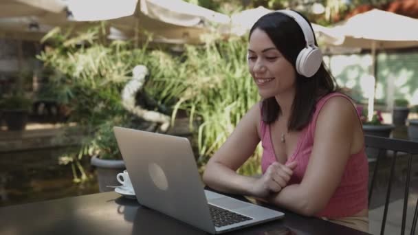 Modayı takip eden genç bir kadın kafeterya terasında bilgisayar kullanıyor. — Stok video