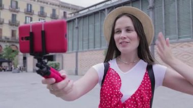 Gülümseyen genç kadın turist seyahat vlog 'u için içerik kaydediyor.