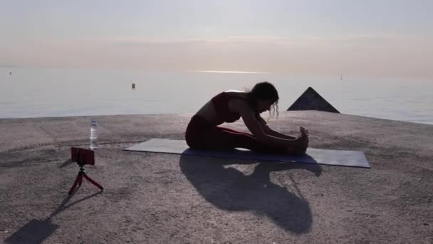 야외에서 요가를 하는 젊은 운동복을 입은 여자 코치 — 비디오