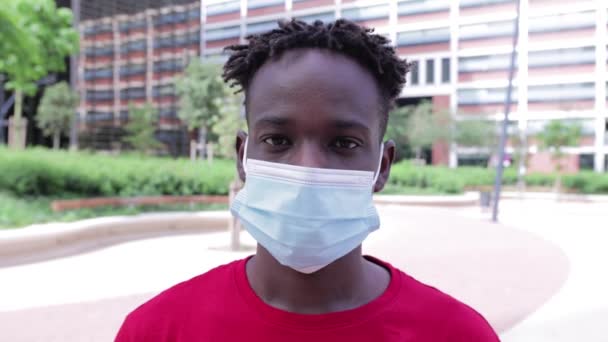 รูปภาพของชายหนุ่มแอฟริกันอเมริกันที่มีความสุข ถอดหน้ากากป้องกันหน้า — วีดีโอสต็อก