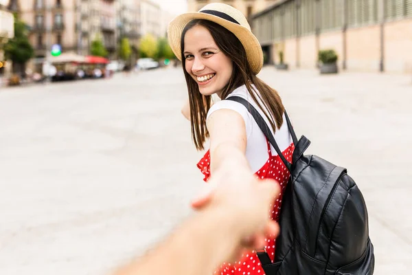 Fröhliche Trendfrau hält Freund die Hand in der Stadt — Stockfoto