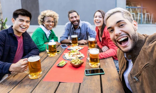 Grupo de amigos multirraciales tomando una selfie con teléfono móvil en el bar de la cervecería — Foto de Stock