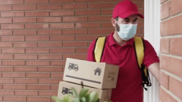 Utusan Hispanik dengan ransel dering bel pintu untuk memberikan paket — Stok Video