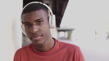 Kulaklıklı Afro-Amerikan bir gencin açık hava portresi.