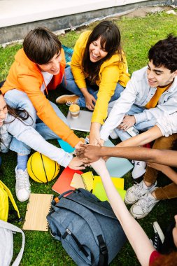 Üniversite kampüsünde el ele tutuşan çeşitli öğrenci grupları. Gençlik toplumu konsepti genç bin yıllık öğrenci grubuyla birlik ve birlik içinde el ele veriyor..