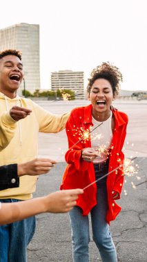 Çeşitli genç Latin Amerikalı arkadaşlar dışarıda birlikte kutlama yaparken ışıldıyorlar. Yeni Yıl 2026 ve kutlama konsepti